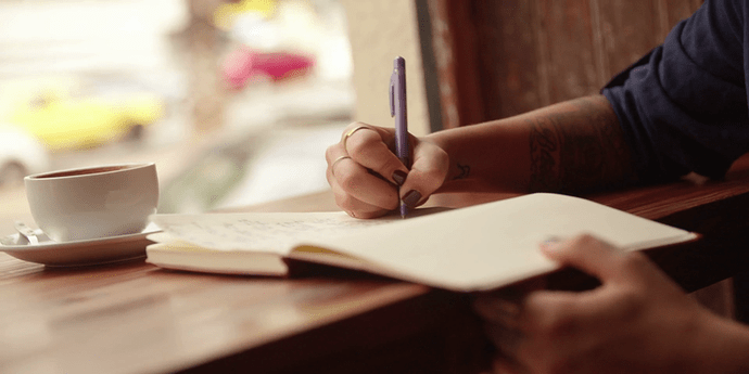 close-up-of-a-woman-writing-journal-in-coffee-shop_reljnvbml_thumbnail-full01_800x400